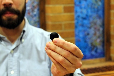 Chris Maddison holds a stone used in the game Go.
