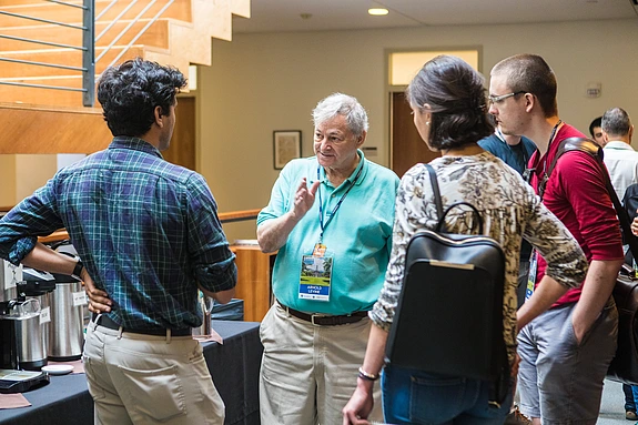 Arnold Levine converses with several students in a circle