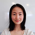 A headshot of Ruozhen Gong.  She is standing in front of a clean whiteboard and wearing a white shirt.
