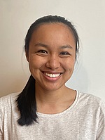 Headshot of Lida Liang.  She is smiling, standing in front of a white wall, and wearing grayish white shirt.
