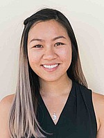A headshot of Anna Ma.  She is smiling, wearing a sleeveless black shirt, and standing in front of a white wall.