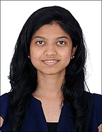 A headshot of Namrata Nadagouda.  She is wearing a navy blue, short-sleeve shirt and standing in front of a white backdrop.