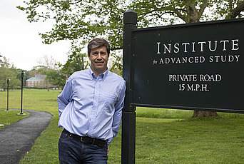Matias Zaldarriaga stands with the entrance sign at the Institute for Advanced Study