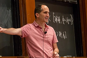 Juan Maldacena speaks on stage in Wolfensohn Hall