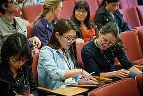 One scholar shows another something on the iPad screen