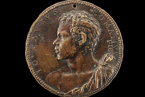 Bronze portrait medal showing a man with curly hair in profile, facing left, in high relief detail with engraved text round the edge