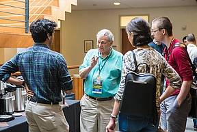 Arnold Levine converses with several students in a circle