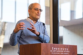 Edward Witten speaks at the podium in Simons Hall at the Institute for Advanced Study