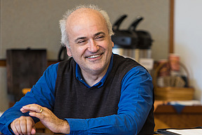 Roberto Tottoli smiles at a conference table