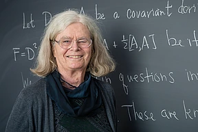 Karen Uhlenbeck poses for a headshot at the blackboard