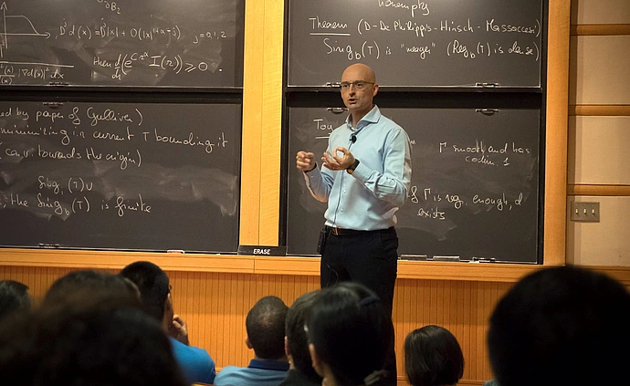Camillo De Lellis lectures at the front of Simonyi Hall 101