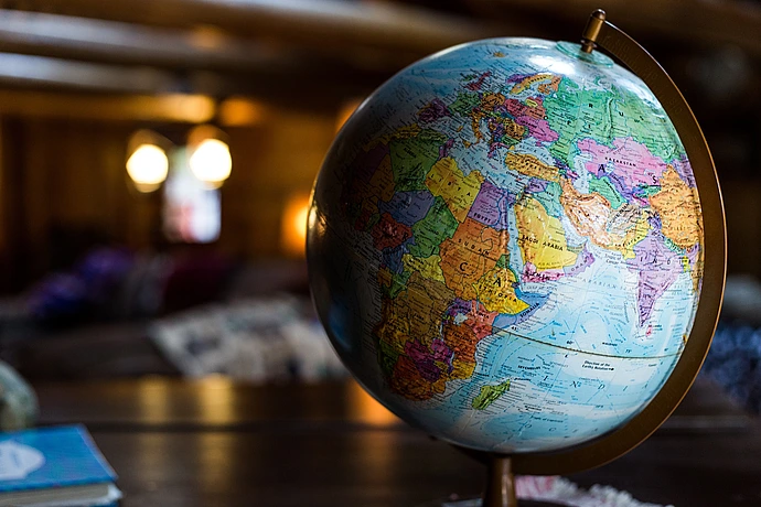 A globe situated in a warmly lit library.