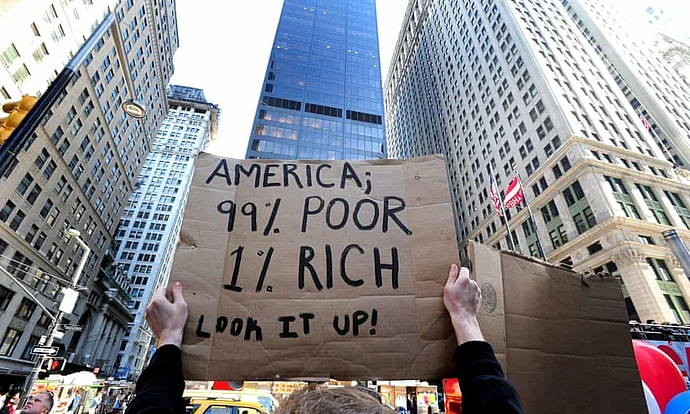 A demonstrator holds a sign that reads "America; 99% Poor, 1% Rich. Look it up!"