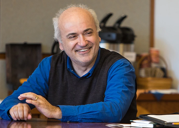 Roberto Tottoli smiles at a conference table