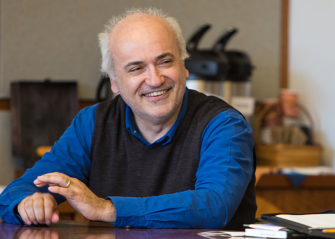 Roberto Tottoli smiles at a conference table