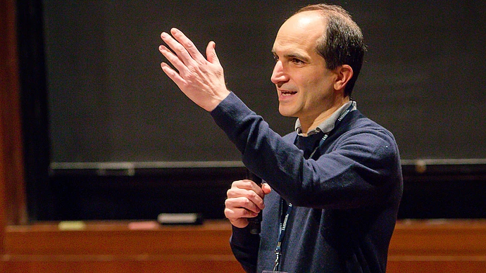 Juan Maldacena speaks on stage in Wolfensohn Hall