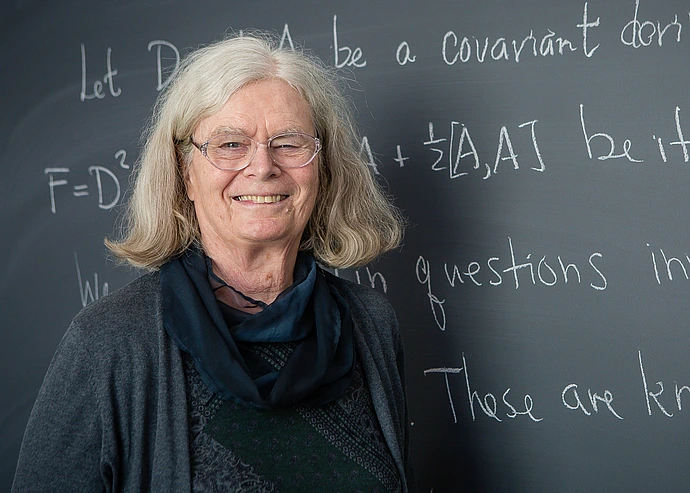 Karen Uhlenbeck poses for a headshot at the blackboard