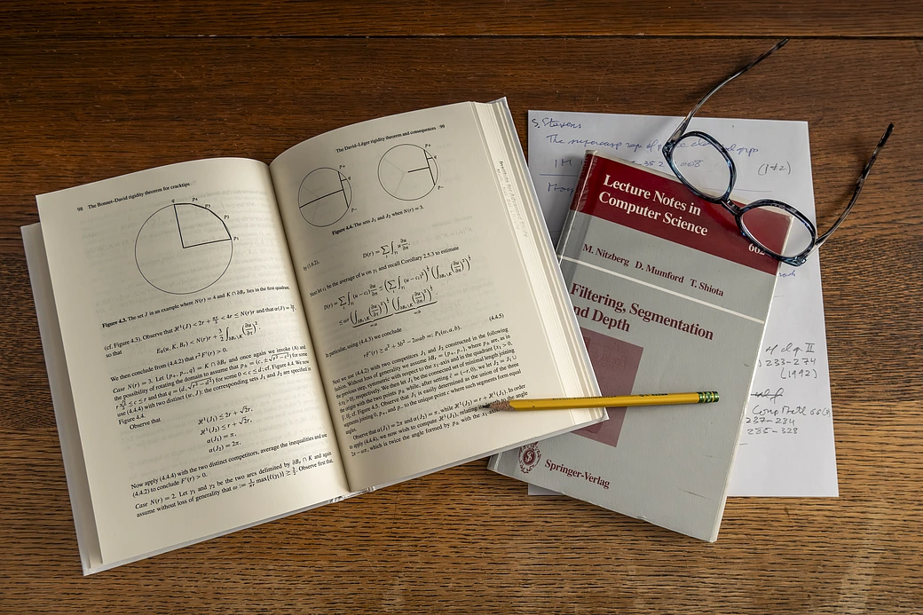 Open math book and papers on table